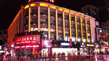 A multi-story hotel with illuminated signage and a large entrance.