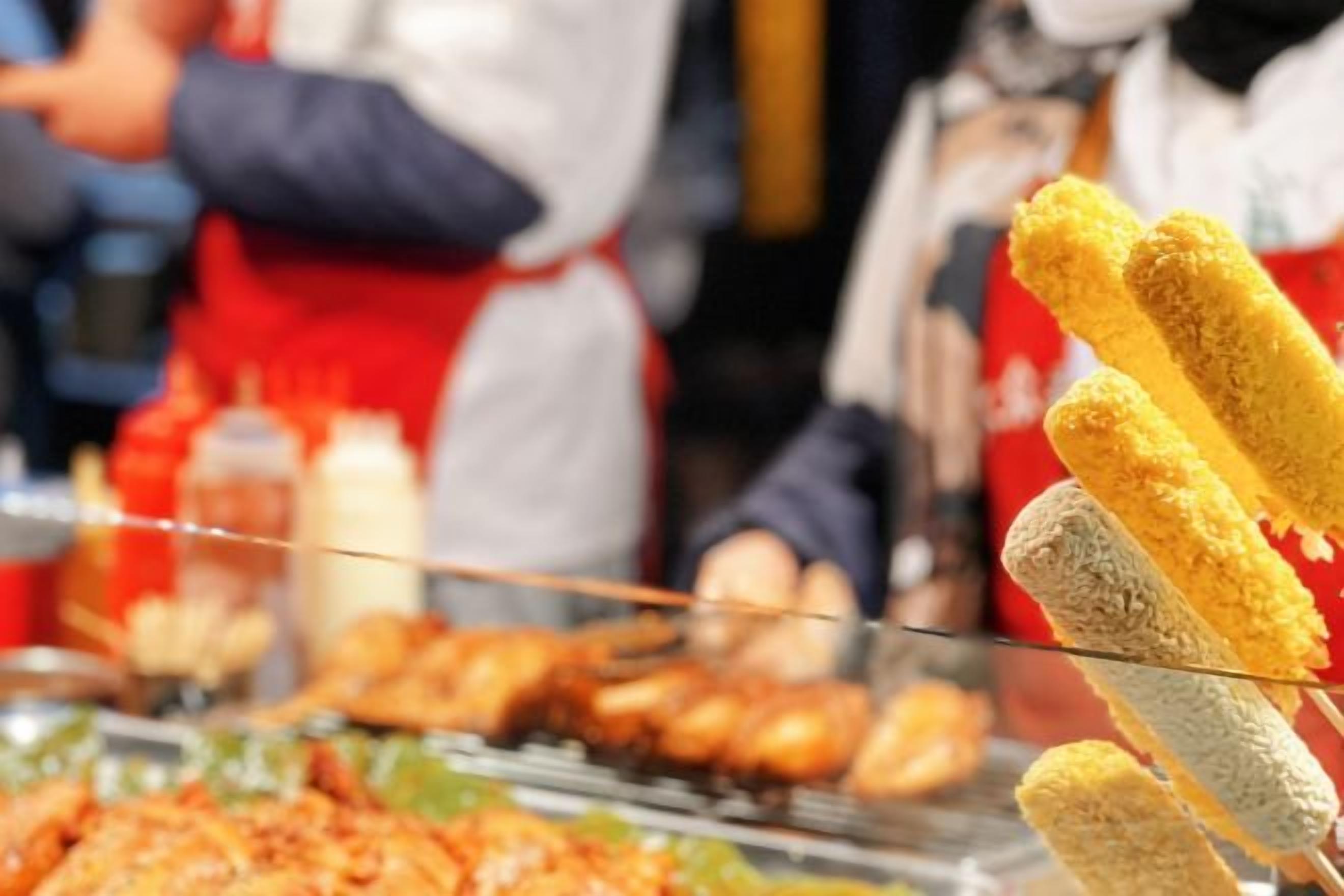 Un puesto de comida con brochetas, probablemente un vendedor ambulante de comida.