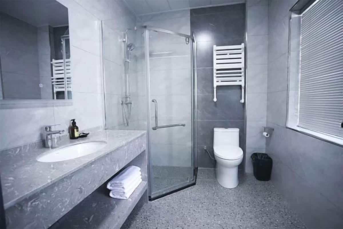 Um banheiro moderno com box de vidro, vaso sanitário branco e pia de mármore.