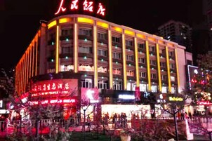 A multi-story hotel with illuminated signage and a prominent entrance.