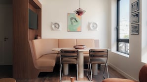 A modern living room with a beige sofa, a round table, and a large window.