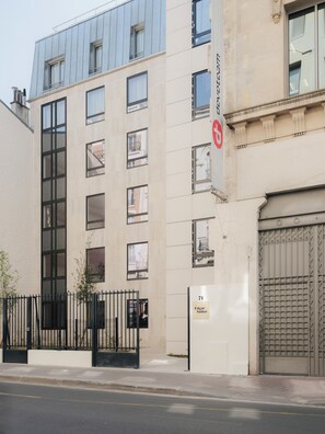 A modern building with a beige facade, large windows, and a gated entrance. - Edgar Suites Levallois - Anatole France (Levallois-Perret)