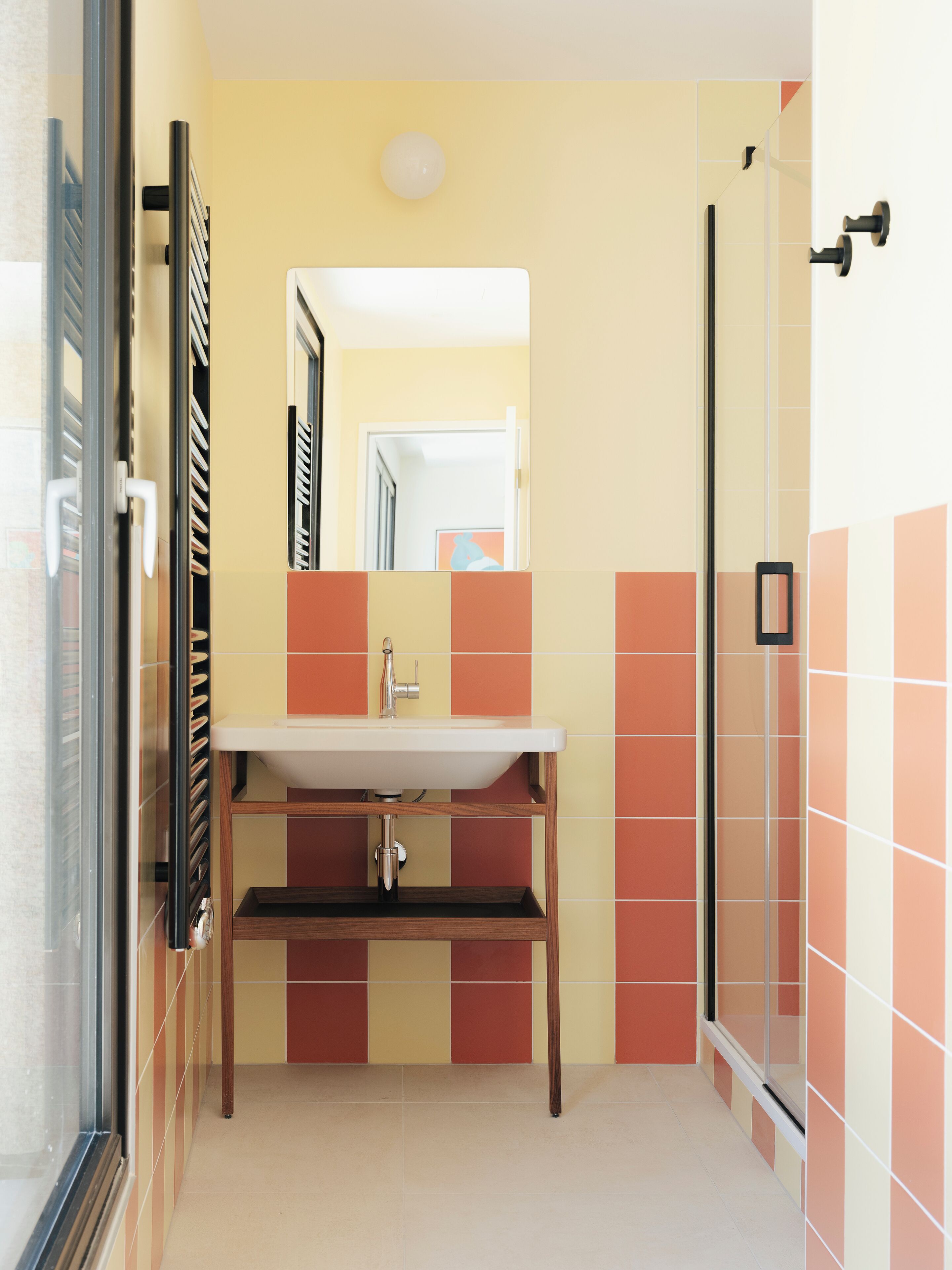 A bathroom with a sink, mirror, and shower.