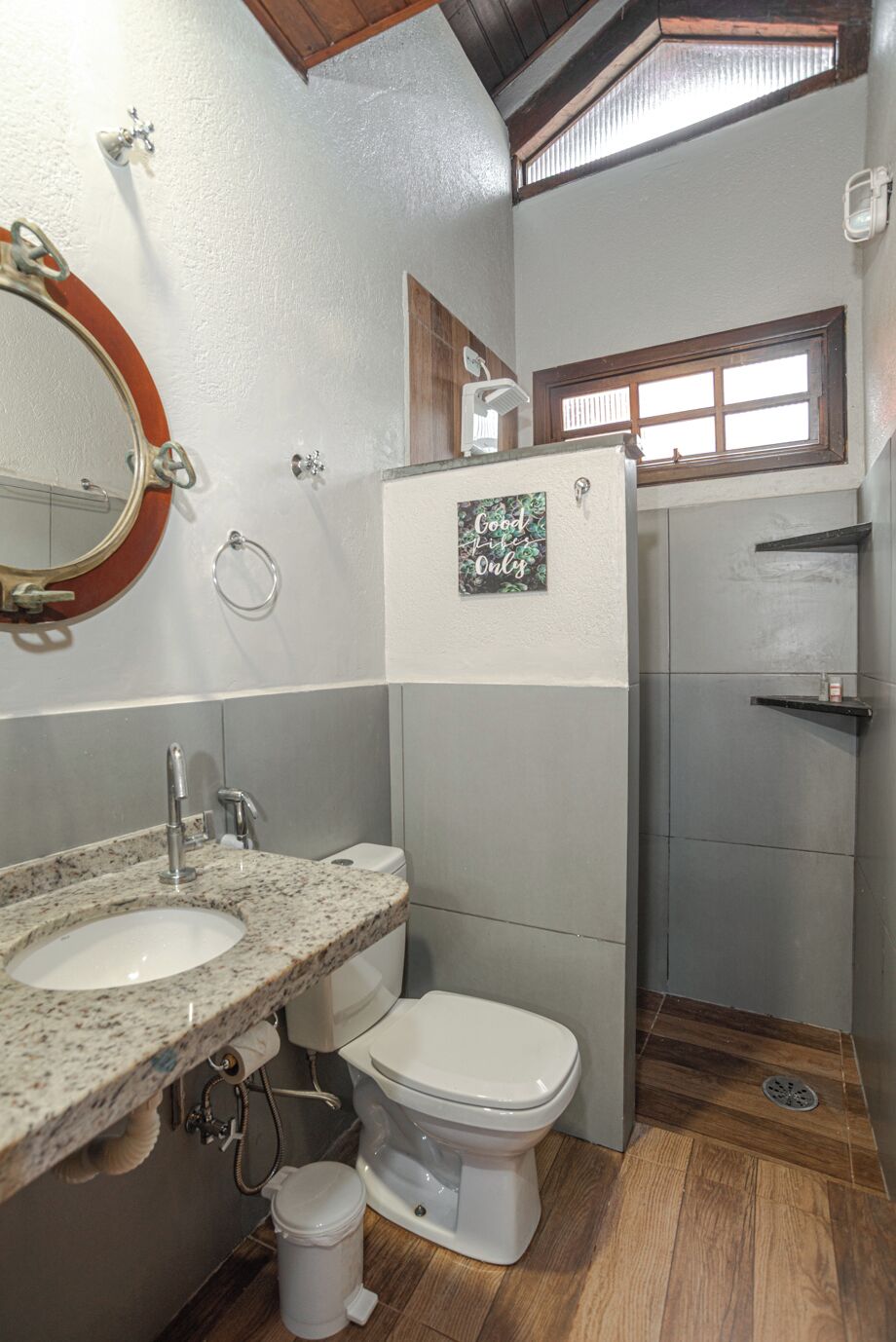 A bathroom with two sinks, a toilet, a shower, and a window.
