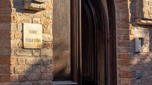 A brick building with an arched entrance labeled "TORRE DELLA LUNA".