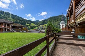 Un village rural avec une église, des bâtiments en bois et un champ verdoyant.