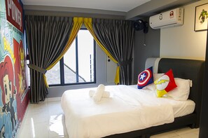 Ein Hotelzimmer mit Bett, Vorhängen, einem Fenster und einer Wand mit Superhelden-Kunstwerken.