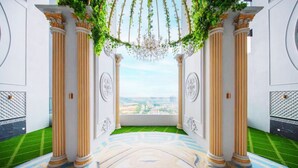 A grand hallway with columns, a chandelier, and a view of the city. - Heroes Home 8pax near Subway station  (Kuala Lumpur)