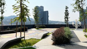 A rooftop garden with a patterned walkway, seating areas, and a decorative lamp post. - Heroes Home 8pax near Subway station  (Kuala Lumpur)