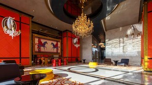 A luxurious lobby with a grand chandelier, red and gold decor, and a large horse-themed painting. - Heroes Home 8pax near Subway station  (Kuala Lumpur)