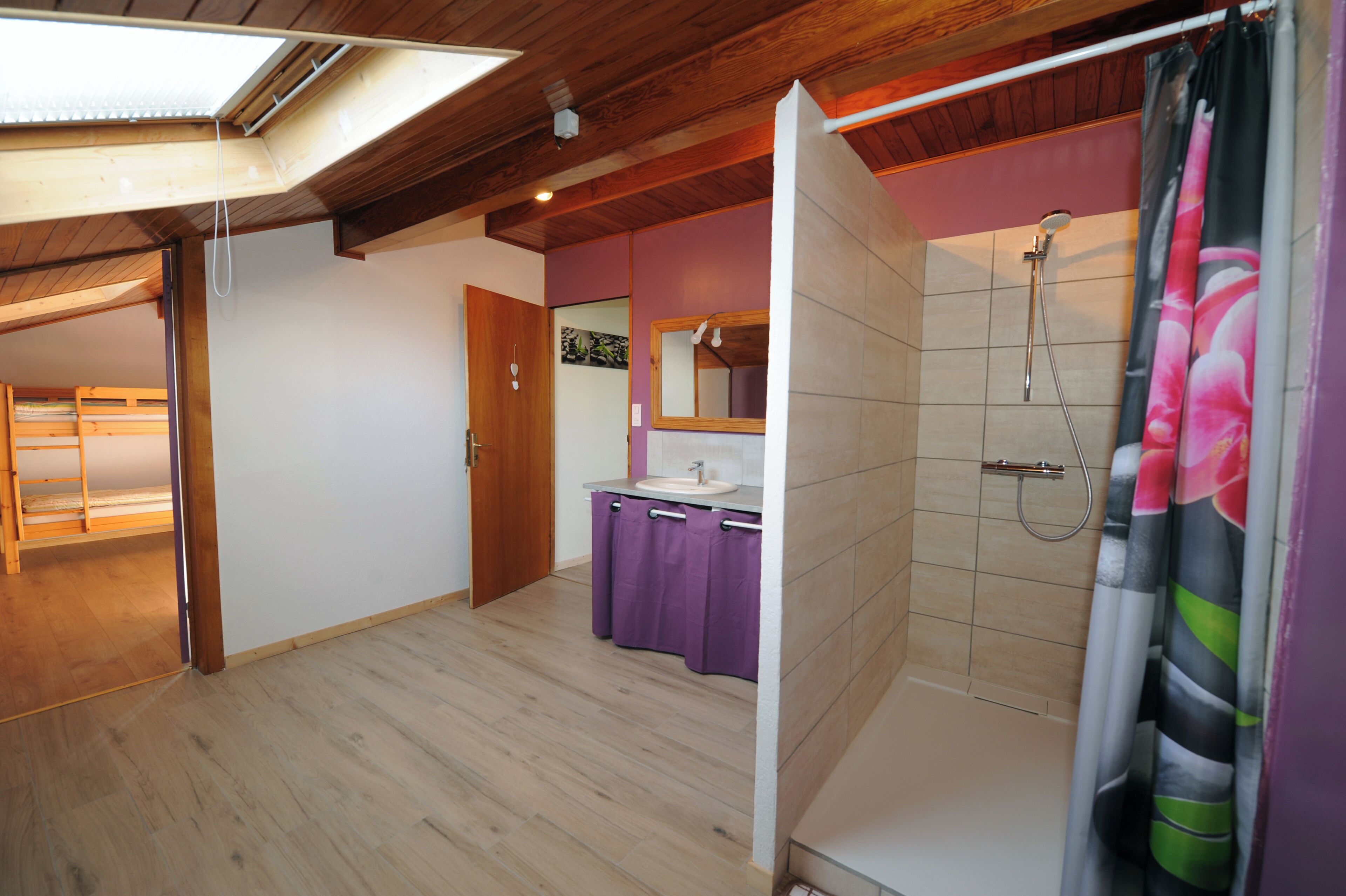 A bathroom with a shower, a sink, and a mirror.