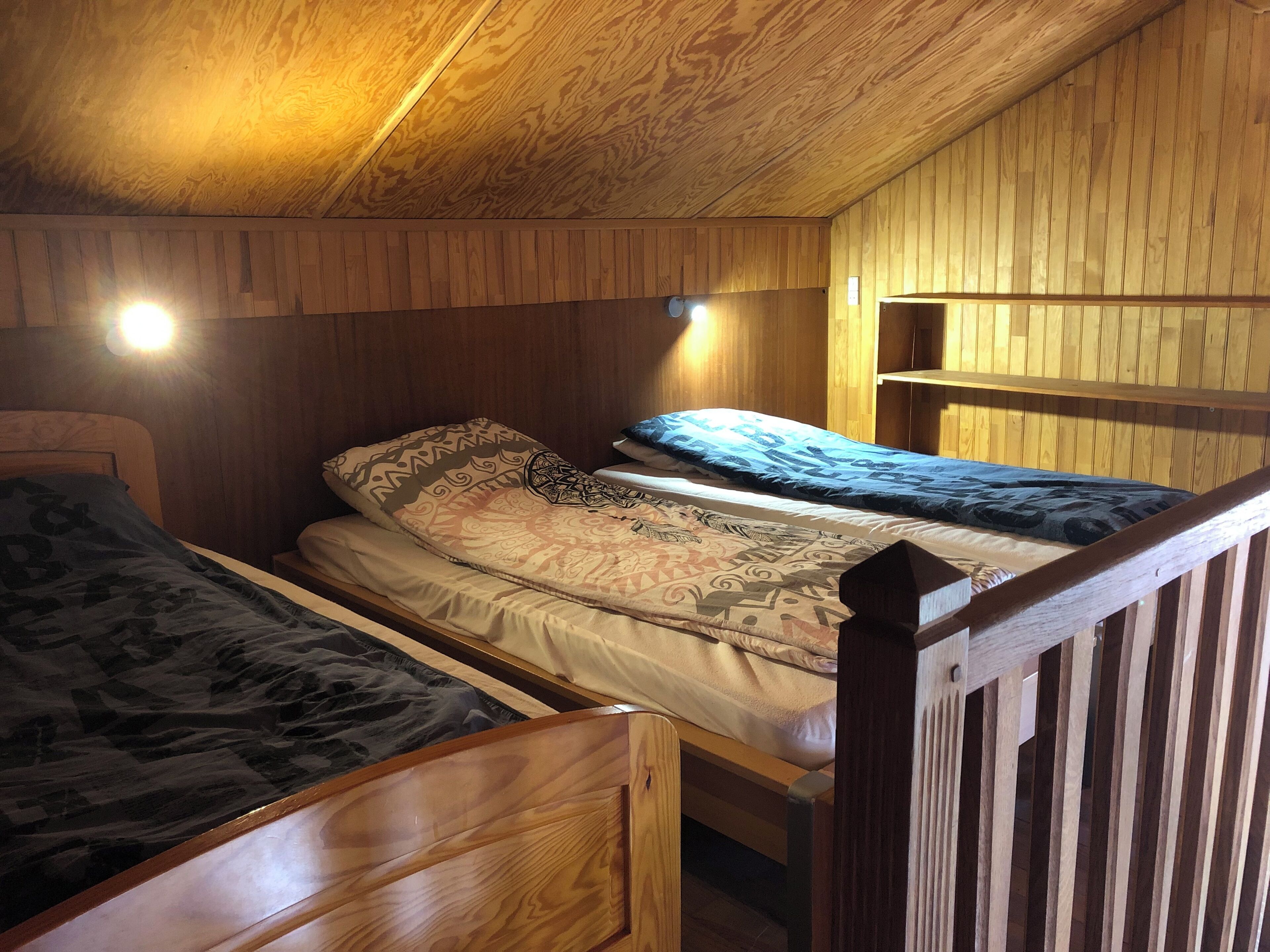 Camera con un letto a castello in legno, dotato di due letti, ognuno con biancheria a motivi.
