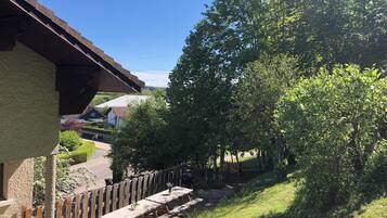 Een uitzicht op een woonwijk met een houten omheining, een picknicktafel en huizen op de achtergrond.