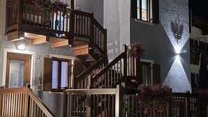 Een meerlaags gebouw met houten balkons, stenen muren en een nachtelijke setting.