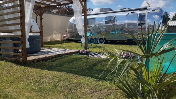 A clear view of a swimming pool, a wooden pergola with a canopy, and a camper van parked in the background. - American caravan🇺🇸 with private SPA, near Beauval (Chabris)