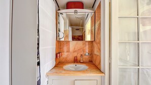 Un baño con lavamanos, espejo y ducha.