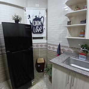 Enjoy cooking in this well-equipped kitchen with a refrigerator, sink, and ample storage.