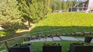 A landscaped area with a gravel path, metal railing, and rectangular planters with greenery. - 200m from ski slopes, Ground floor, terrace, balcony, tv, ski locker, 45m², Valfréjus (Valfréjus)