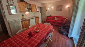 A compact living space with a dining area, kitchenette, and a red sofa. - 200m from ski slopes, Ground floor, terrace, balcony, tv, ski locker, 45m², Valfréjus (Valfréjus)