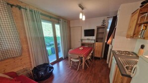 A compact living space with a dining area, kitchenette, and a red sofa. - 200m from ski slopes, Ground floor, terrace, balcony, tv, ski locker, 45m², Valfréjus (Valfréjus)