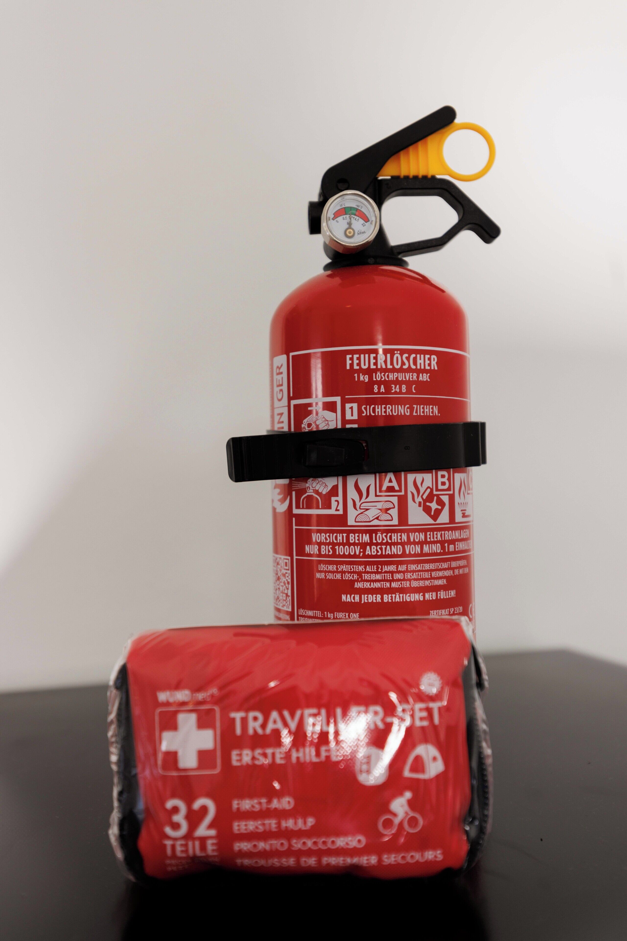 Ein Feuerlöscher und eine Erste-Hilfe-Ausrüstung auf einem Tisch.