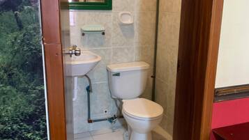 A small bathroom with a toilet, sink, and mirror.