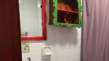 A bathroom with a white sink, a toilet, and a mirror with a red frame.
