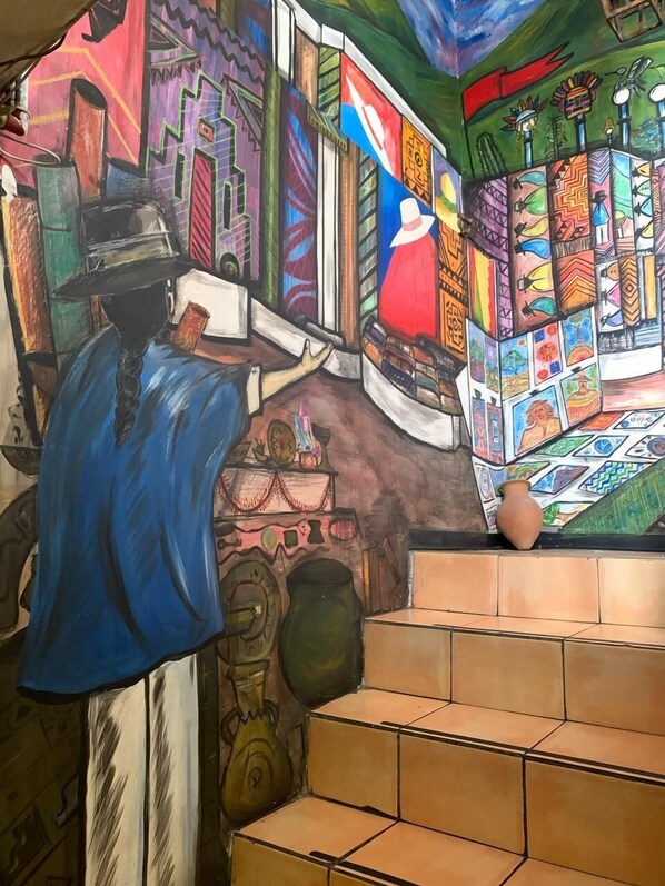 A vibrant mural with geometric patterns and cultural motifs. - Hostal Flying Donkey (Otavalo)