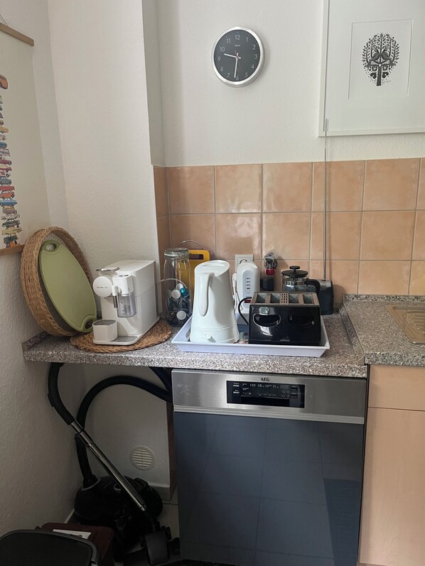A kitchen with a coffee maker, toaster, and a clock on the wall. - Friendly and quiet apartment close to the old town. (Stade)