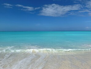 A beach with clear turquoise water and a sandy shore. - Treasure Cay Beach Villa Magic (Treasure Cay)