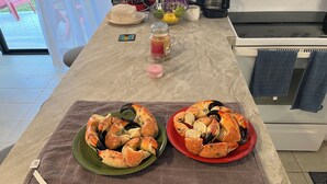 A kitchen counter with two plates of cooked lobster on a marble countertop. - Treasure Cay Beach Villa Magic (Treasure Cay)