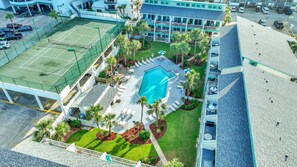 Ein Hotel mit Tennisplatz, Schwimmbad und angelegtem Garten.