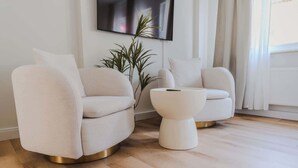 A modern living room with two white sofas and a white coffee table.