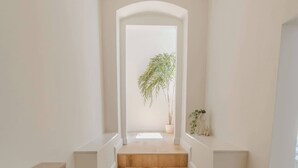 A staircase leading to a landing with a potted plant.