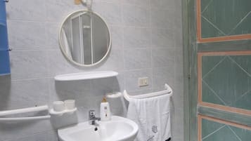 Ein Badezimmer mit einem weißen Waschbecken, einem Spiegel und einem Handtuchhalter.