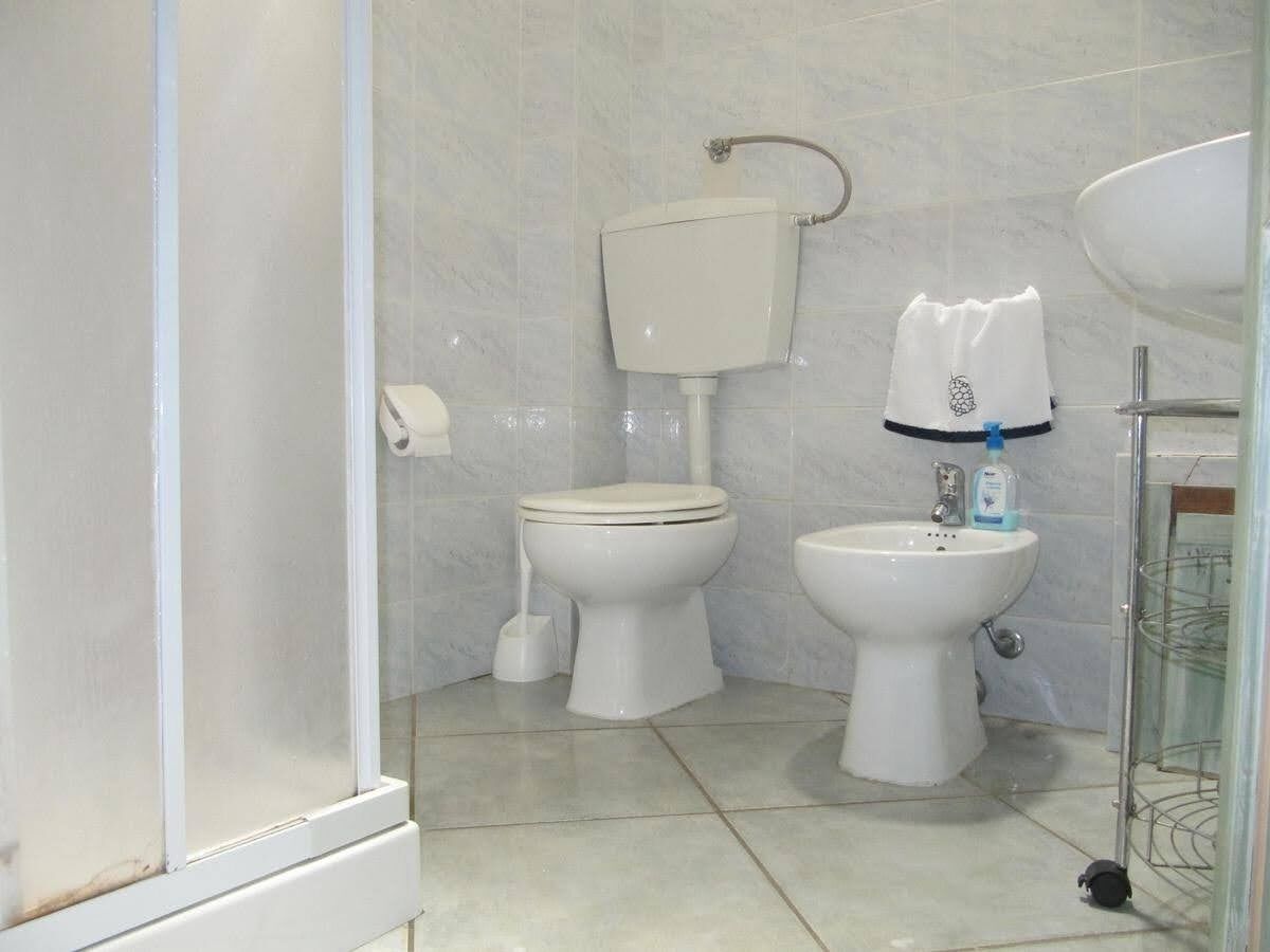 Un baño con inodoro, bidé y lavamanos.