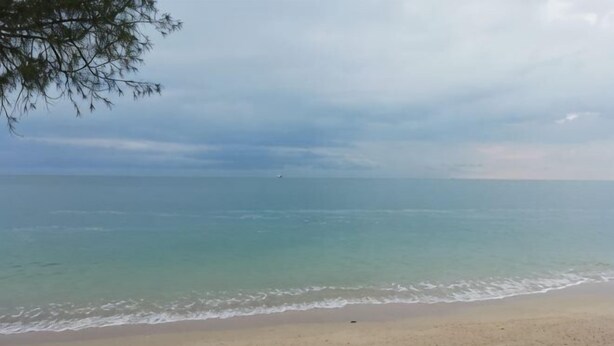 A beach with a sandy shore and calm sea under a cloudy sky. - Beihai Hai Yi Hurried That year Inn (Second inn) (Beihai)