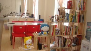 A room with a red table, red chairs, a bookshelf, and a water dispenser. - Beihai Hai Yi Hurried That year Inn (Second inn) (Beihai)