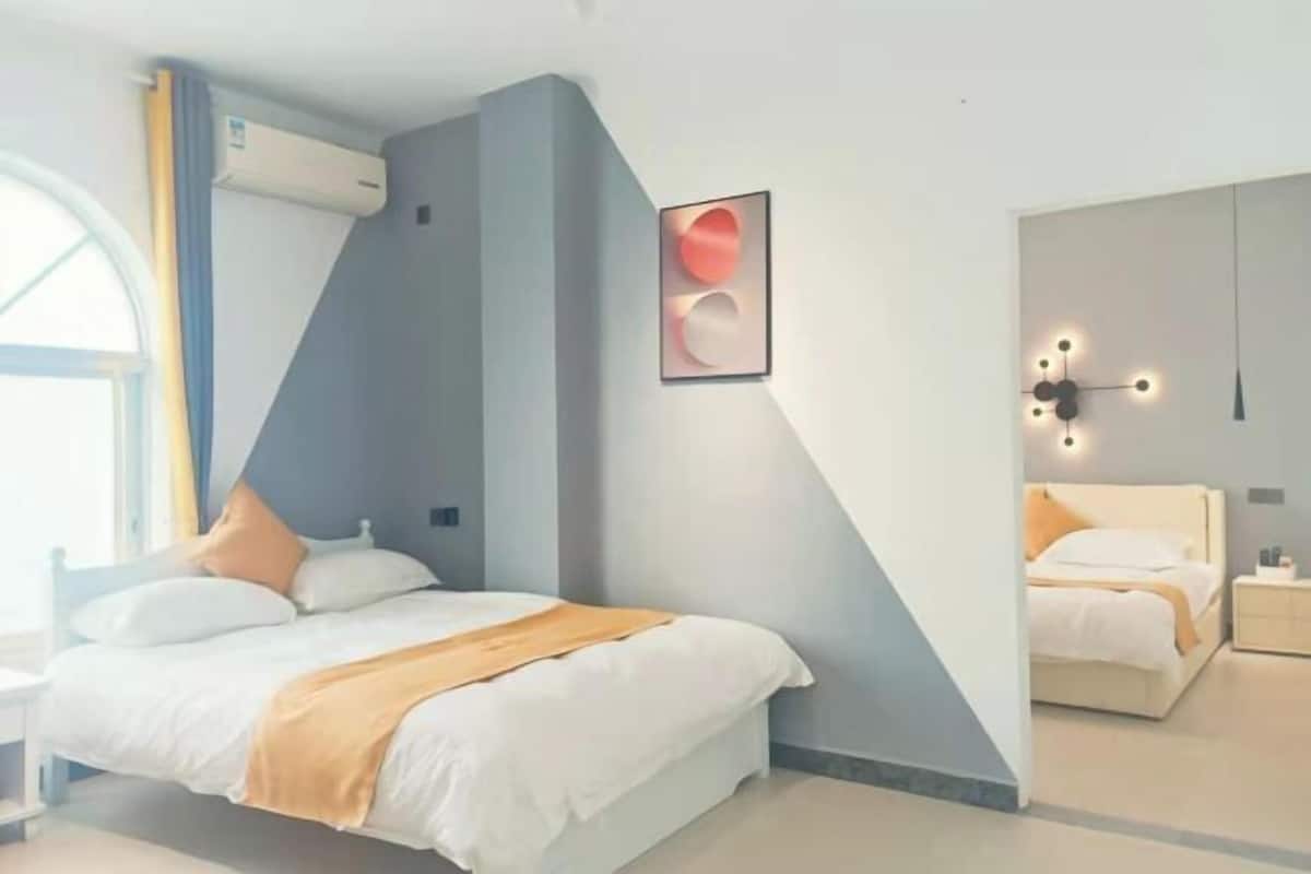 A modern bedroom with a bed, bedside tables, and a wall-mounted light fixture.