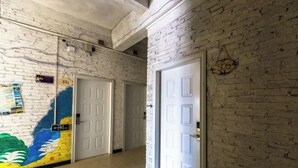 A hallway with white brick walls, white doors, and a colorful mural on the left wall. - Beihai Hai Yi Hurried That year Inn (Second inn) (Beihai)