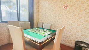 A room with a green pool table, four chairs, a window with a view of trees, and a no-smoking sign on the wall. - Shell Hotel (Shanghai Pujiang Town Zhuyuan Road) (Shanghai)