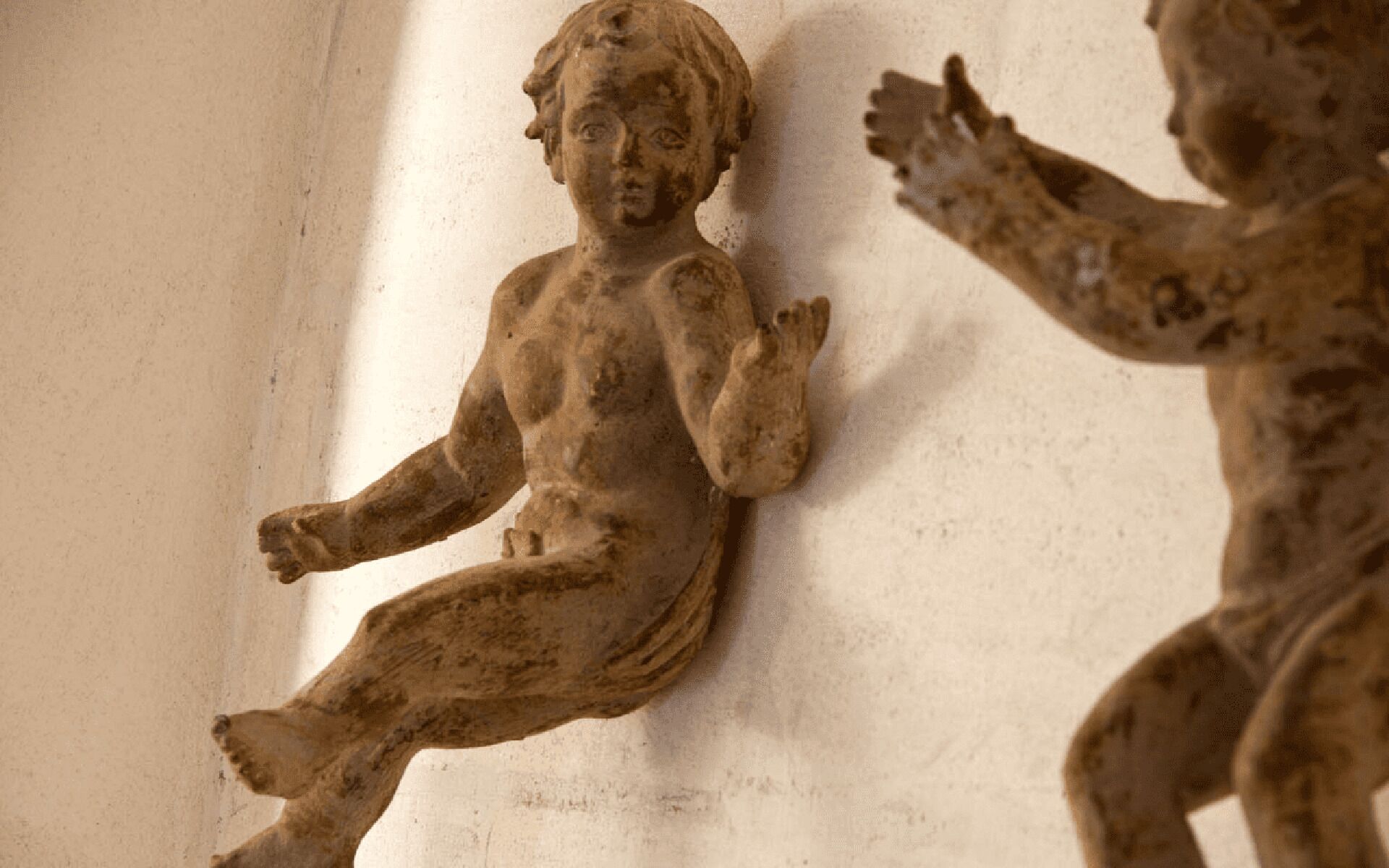 Une sculpture représentant un enfant dans une pose dynamique, probablement située dans un bâtiment public ou historique.