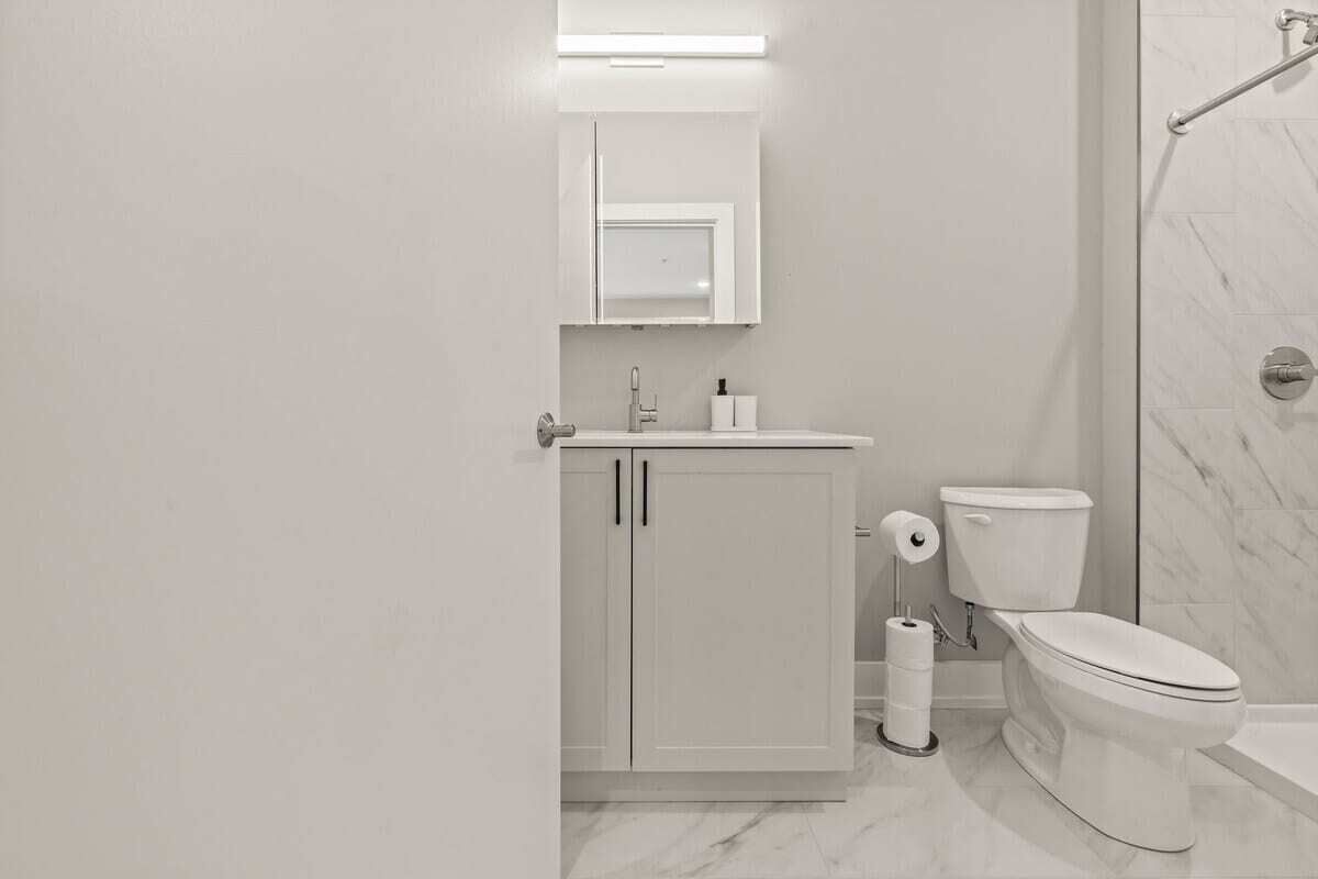 A modern bathroom with a toilet, sink, and shower area.