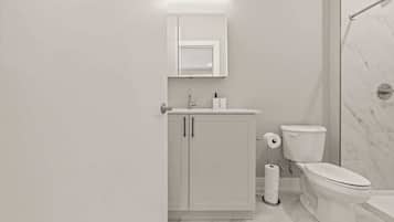 A modern bathroom with a toilet, sink, and shower area.