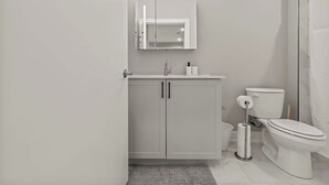 Un baño moderno con inodoro, lavabo y espejo.