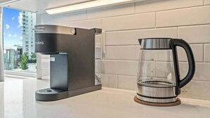 Une cuisine moderne avec une machine à café élégante et une verseuse en verre posée sur le plan de travail.