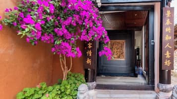 Una entrada tradicional con puerta de madera, una escalera y un letrero con caracteres chinos.