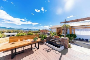 A wooden deck with a bench, a small water feature, and potted plants. - Jingfengtang Guest House (Lijiang)