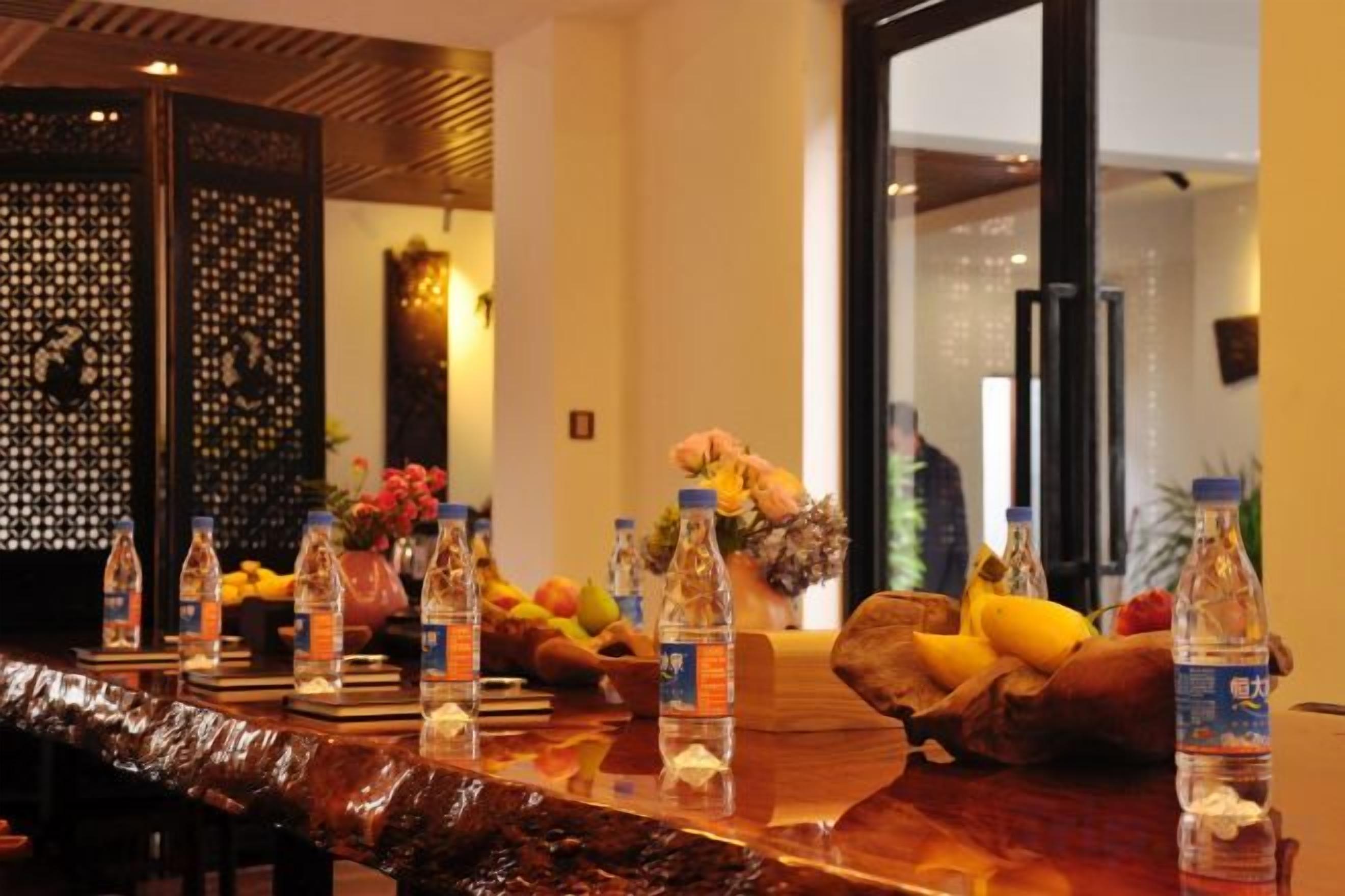 A reception area with a wooden reception desk, water bottles, and a vase with flowers.
