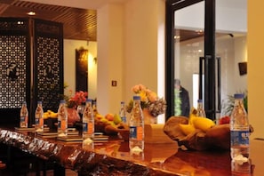 A reception area with a wooden reception desk, water bottles, and a vase with flowers.